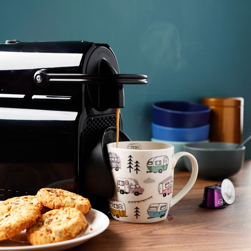 Caravan porcelain mug styled with coffee machine and biscuits
